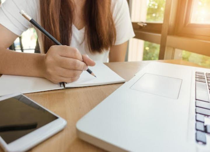adolescente escribiendo frente a un ordenador